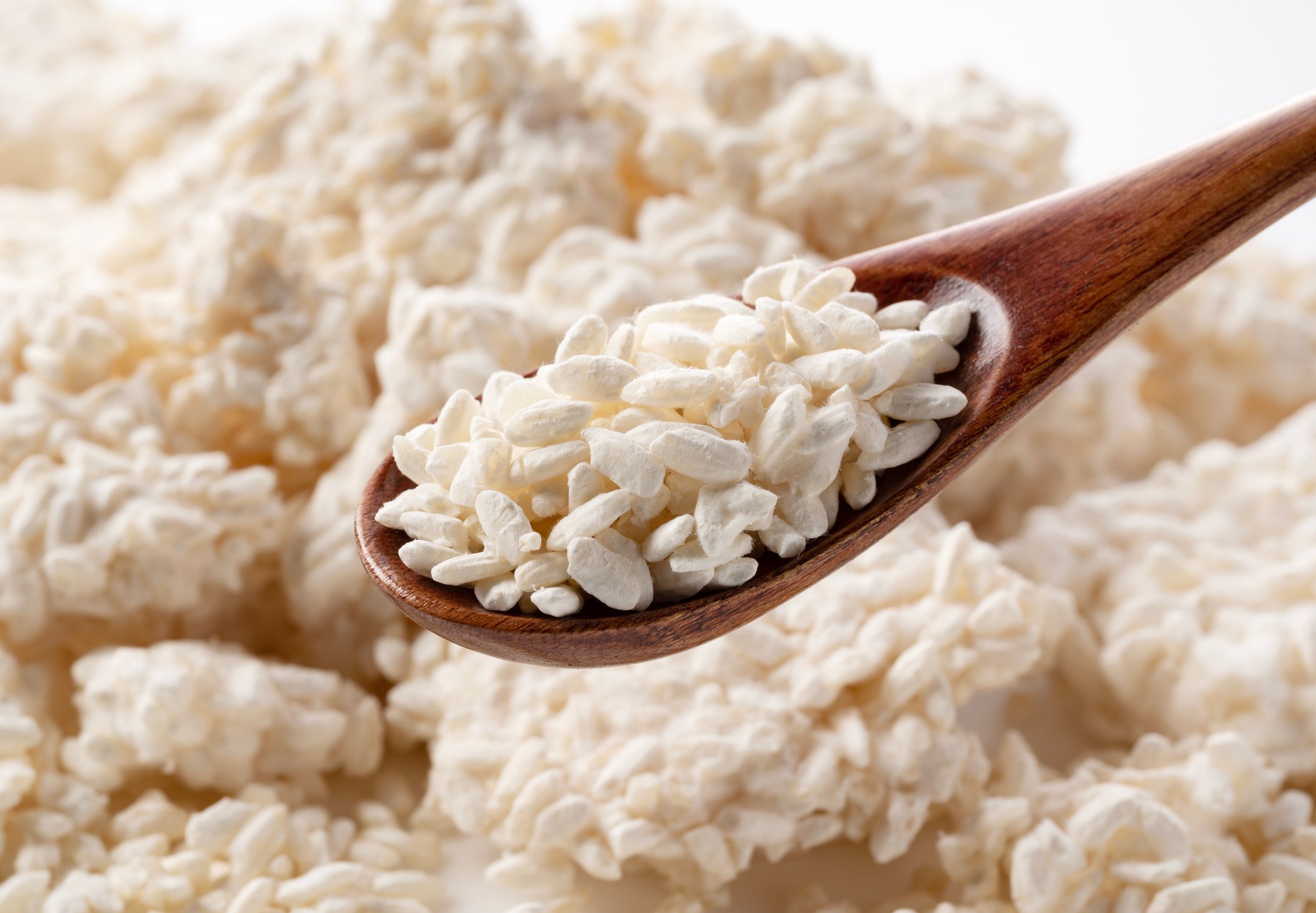 Wooden spoon and rice koji on white background. Koji mold.