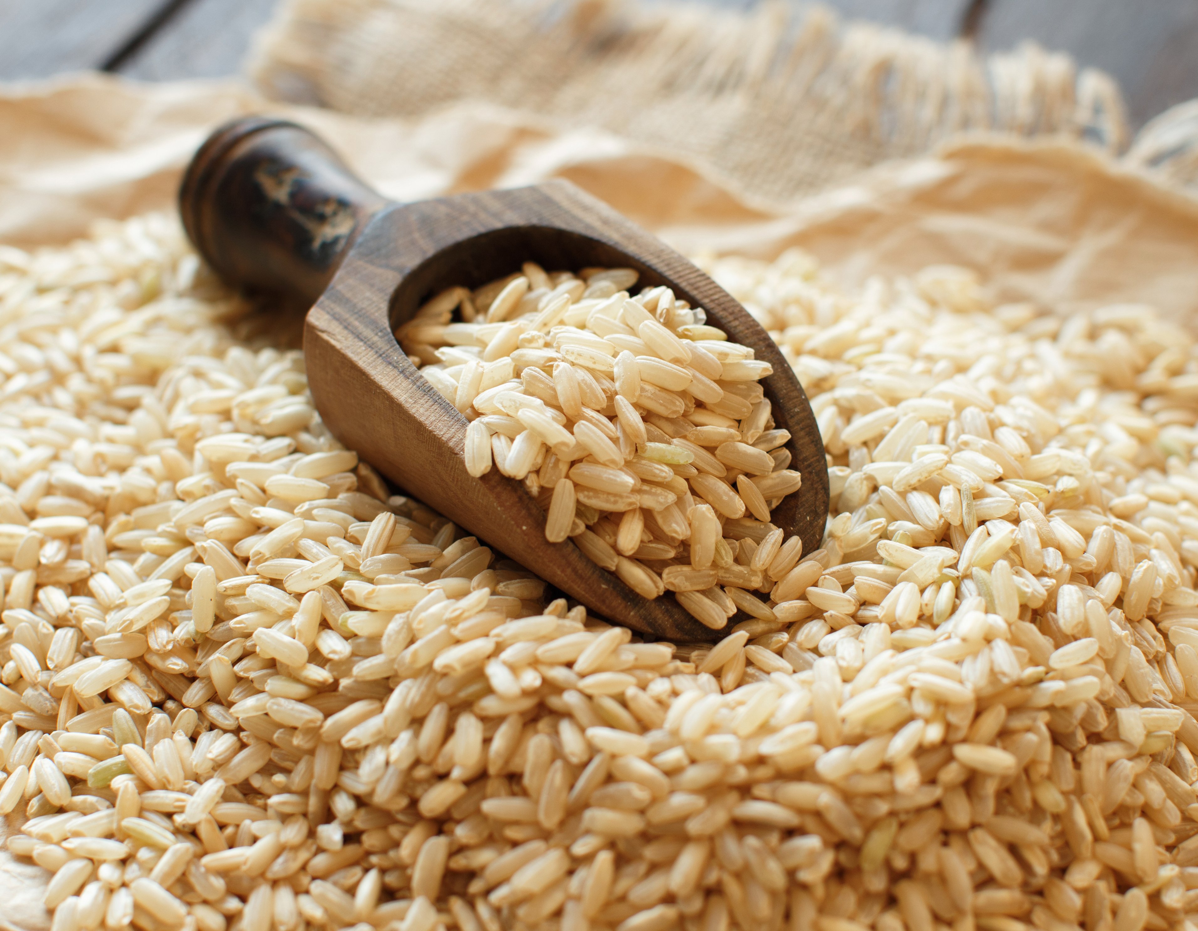 Pile of Brown rice with a wooden spoon